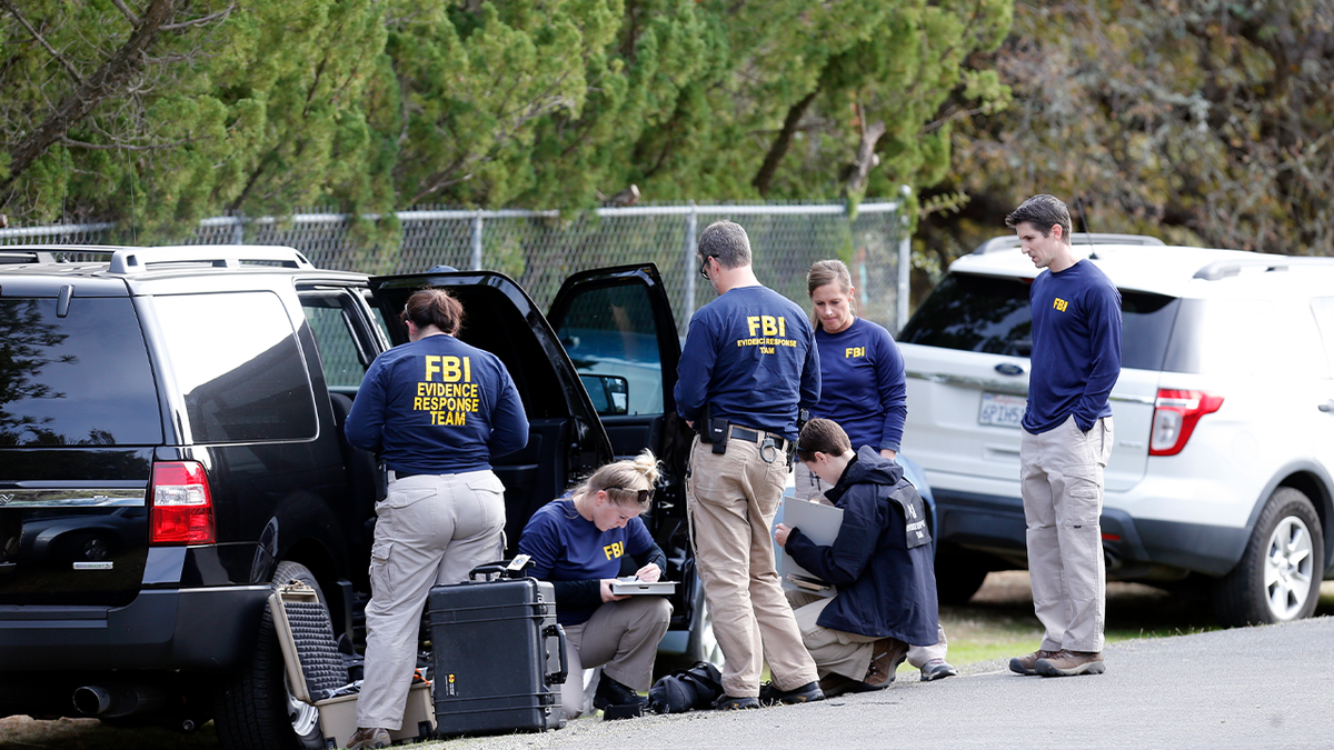 FBI agents by cars on side of road