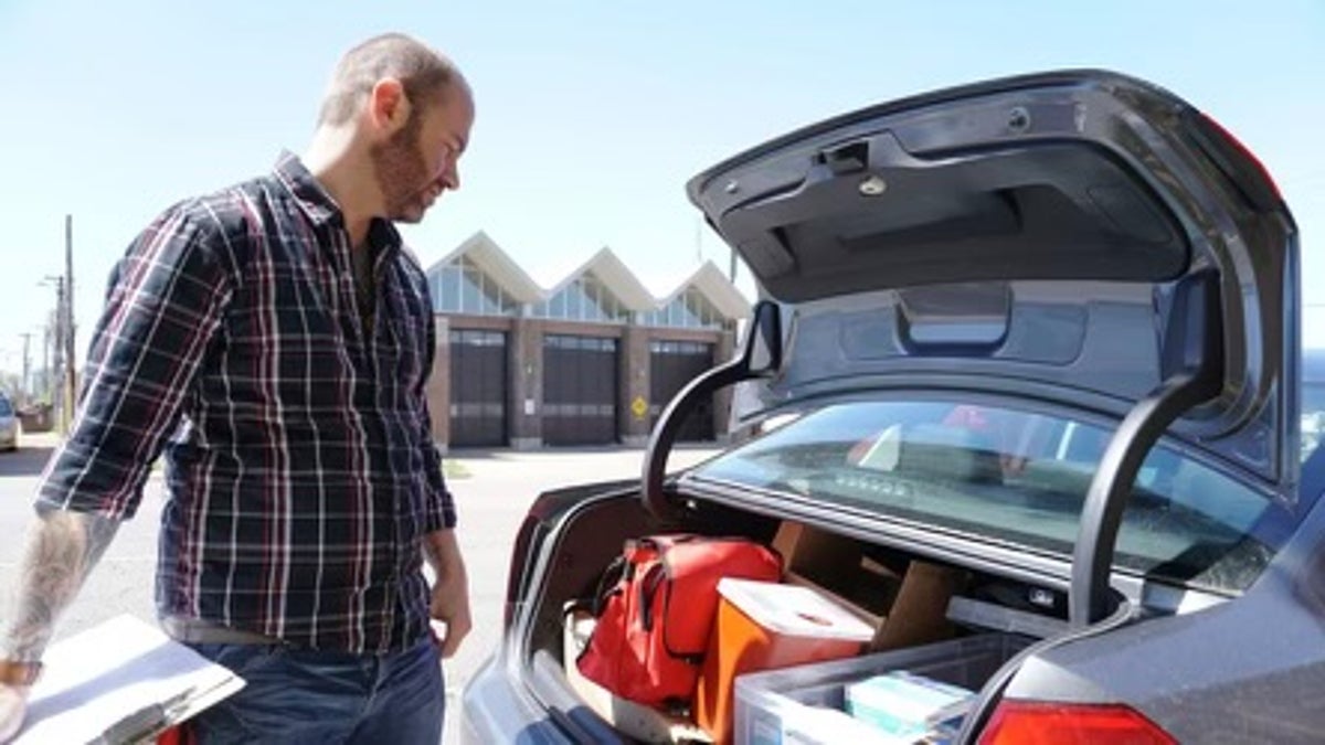 Man with medical supplies in the trunk of a car