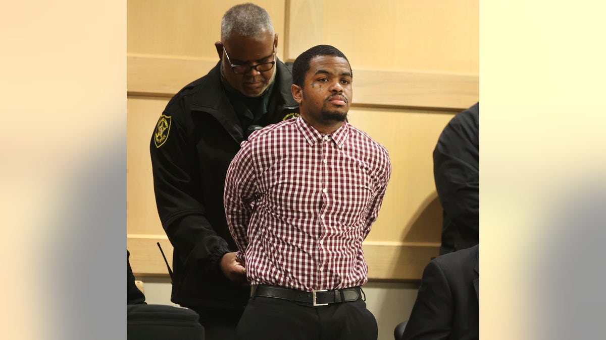 Trayvon Newsome is handcuffed in court.