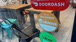 We Deliver, Doordash, Grubhub and Uber Eats signs on restaurant door, New York City. (Photo by: Lindsey Nicholson/UCG/Universal Images Group via Getty Images)
