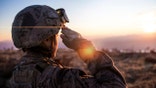 Female Army Solider Saluting against sunset sky