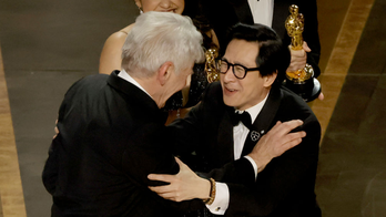 Ke Huy Quan embraced onstage by presenter Harrison Ford as 'Everything Everywhere All At Once' wins Oscar