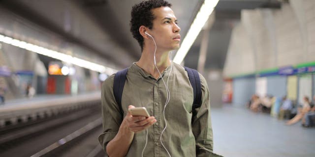 Man confused in a public place wondering whether to access Wi-Fi.