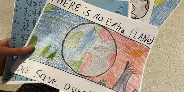 La profesora de educación de la Universidad de Oregón, Sarah Stapleton, sostiene dibujos y cartas de estudiantes de primaria que piden a los legisladores que detengan el cambio climático, luego de testificar en una audiencia en el Capitolio del Estado de Oregón en Salem, Oregón, el jueves 9 de marzo de 2023, a favor de un proyecto de ley. que requieren educación sobre el cambio climático en las escuelas públicas desde el jardín de infantes hasta el duodécimo grado.
