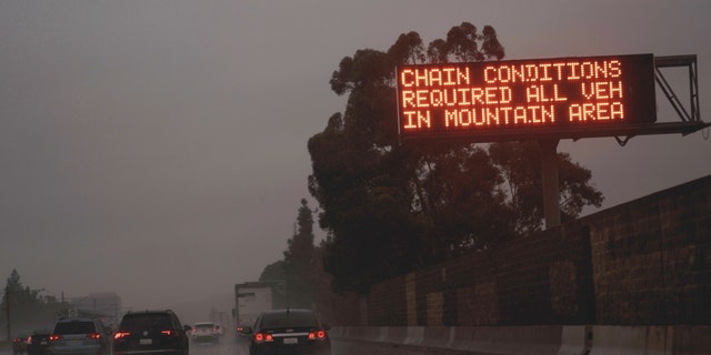 A "Chain Conditions Required" sign on the freeway during a storm in La Canada, California, on Friday, Feb. 24, 2023. 