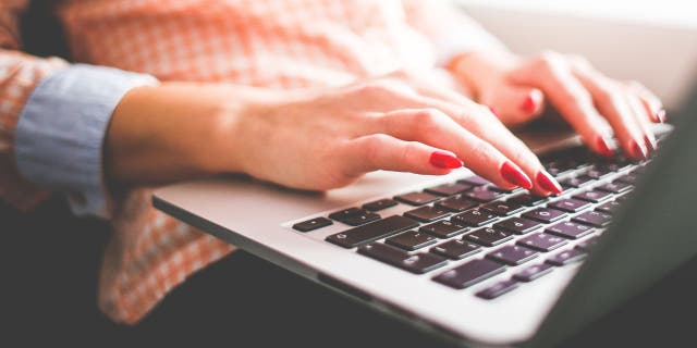 Wanita mengetik di laptop