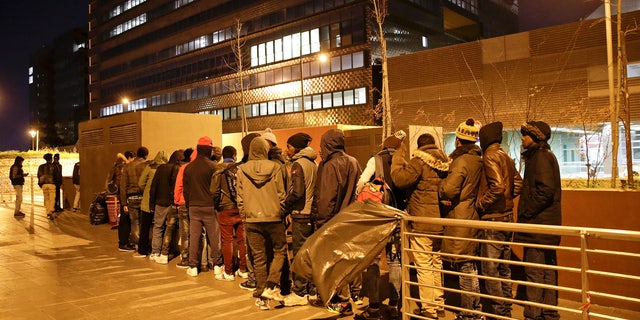 File: Migrants queue for food at a bus station in front of the Tiburtina railway station in Rome March 8, 2017.