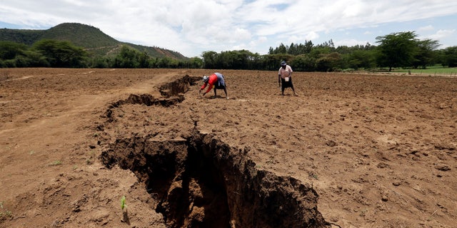 Women work on their farm near a chasm suspected to have been caused by a heavy downpour along an underground fault line near the Rift Valley town of Mai Mahiu, Kenya, March 28, 2018.