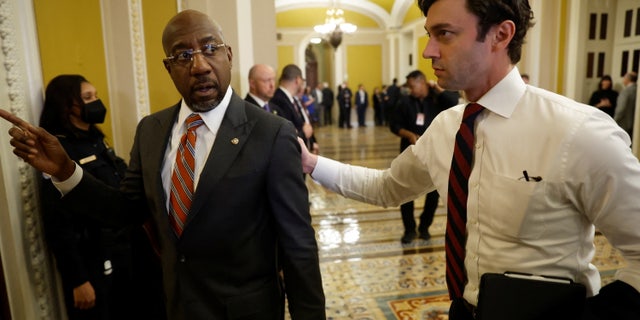 Senators Raphael Warnock (D-GA), left, and Jon Ossoff (D-GA) return to the Senate floor following the Senate Democrats weekly policy lunch at the U.S. Capitol. The party lunches are expected to be private affairs.