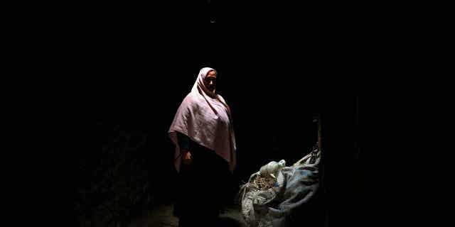 Aziza Rahimi, 35, poses for a photo inside her house in Foladi Valley in Bamiyan, Afghanistan, March 2, 2023. Rahimi gave birth, but her baby died shortly after.