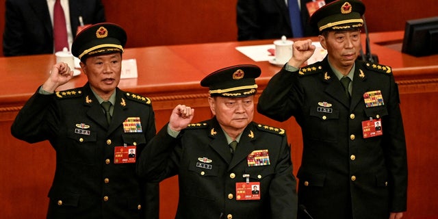 Zhang Youxia (C), newly elected deputy chairman of the Central Military Commission of the People's Republic of China, takes the oath of office with Central Military Commission members He Weidong and Li Shangfu after they were elected during the fourth plenary session of the National People's Congress (NPC) at the Great Hall of the People in Beijing on March 11, 2023. 