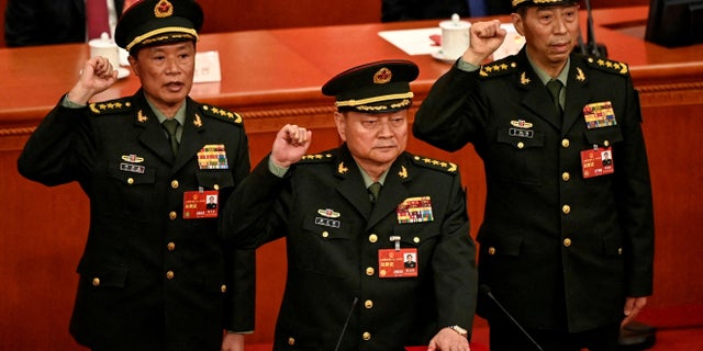 Zhang Youxia (Tengah), Wakil Ketua Komisi Militer Pusat Republik Rakyat Tiongkok yang baru terpilih, bersumpah dengan anggota Komisi Militer Pusat He Weidong dan Li Shangfu setelah mereka terpilih selama sesi pleno keempat Kongres Rakyat Nasional (NPC) di Aula Besar Rakyat di Beijing pada 11 Maret 2023.