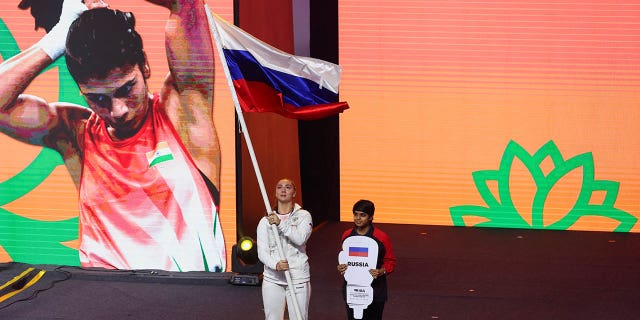 The flag-bearer from Russia's boxing team carries her country's national flag during the opening ceremony of Women's World Boxing Championships at Indira Gandhi Indoor stadium in New Delhi, India, March 15, 2023.