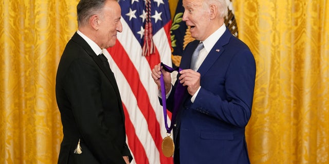 U.S. President Joe Biden presents singer Bruce Springsteen with a National Medal of Arts during a ceremony in the East Room at the White House in Washington, U.S., March 21, 2023. REUTERS/Kevin Lamarque