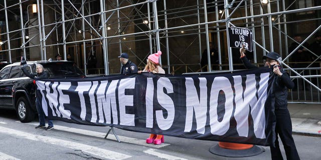 Protesters hold a sign following the indictment of former US President Donald Trump by a Manhattan grand jury following an investigation into the silence of money paid to porn star Stormy Daniels, in New York City, US, March 30, 2023.