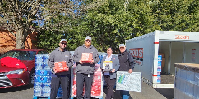 Captain Angelica Spence (second from right, above) holds supplies, along with staff members from Superior Beverage.