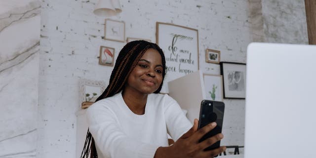 Woman staring into her iPhone.