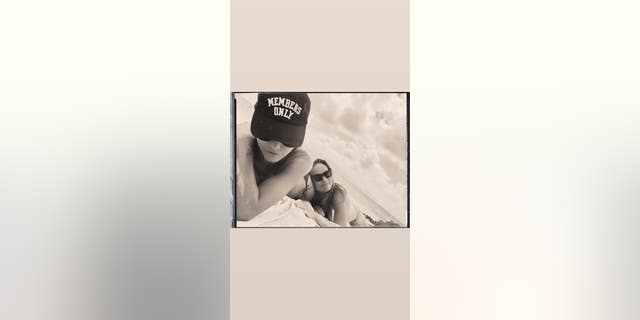 Olivia Wilde's friend Molly Howard, left, sported a "Members Only" hat while Wilde laid on her in a white bikini.