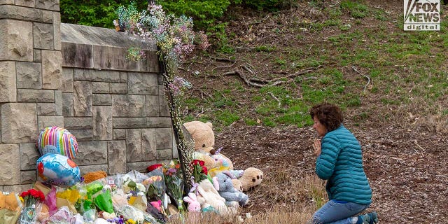 A mourner visits a memorial outside of The Covenant School for the six victims who were killed in a mass shooting in Nashville, Tennessee on Tuesday, March 28, 2023. 