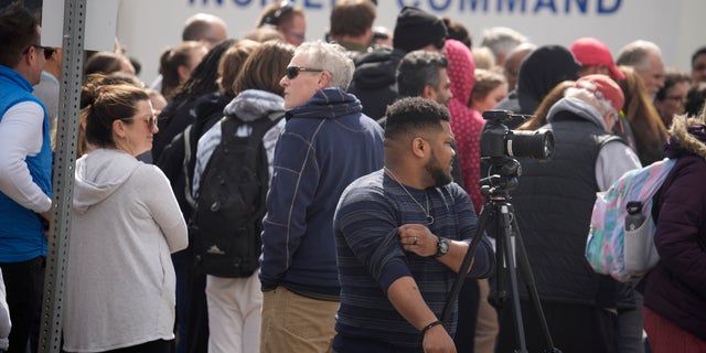 Parents wait for students to be walked out after two administrators shot and wounded after a handgun was found during a daily search of a student at Denver East High School Wednesday, March 22, 2023, in Denver. 