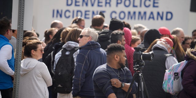 Parents wait for students to be walked out after two administrators shot and wounded after a handgun was found during a daily search of a student at Denver East High School Wednesday, March 22, 2023, in Denver.
