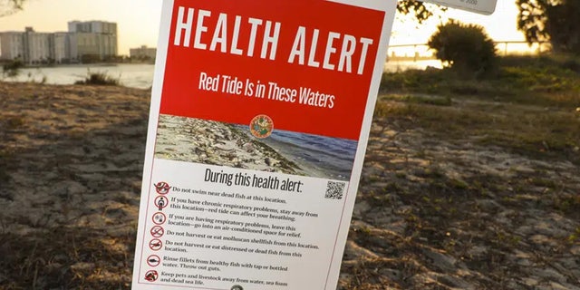A health alert sign warns visitors to Sand Key Park of the presence of Red Tide in the surrounding water on Thursday, March 9, 2023, in Pinellas County, Fla. 