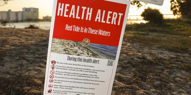 A health alert sign warns visitors to Sand Key Park of the presence of Red Tide in the surrounding water on Thursday, March 9, 2023, in Pinellas County, Fla.