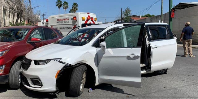 A member of the Mexican security forces stands next to a white minivan with North Carolina plates and several bullet holes where gunmen kidnapped four U.S. citizens who crossed into Mexico from Texas Friday, March 3, 2023. 