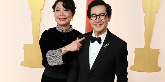 Echo Quan and Ke Huy Quan smile before walking into the Dolby Theatre. 