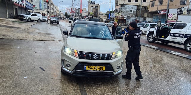 Investigators inspect U.S. Marine veteran David Stern's car after a Palestinian shot him.