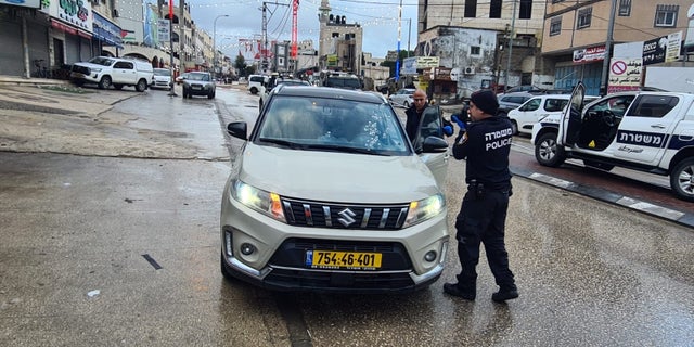 Investigators inspect U.S. Marine veteran David Stern's car after a Palestinian shot him.