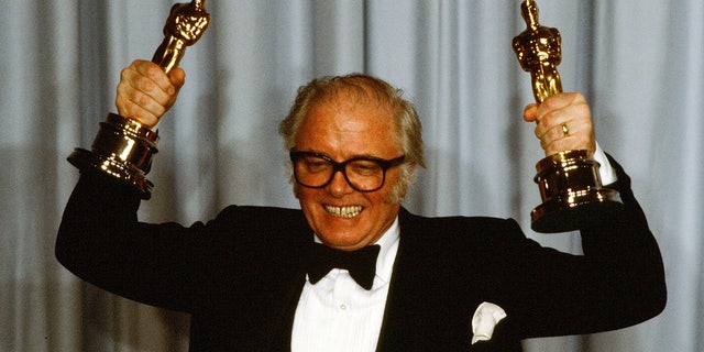 Richard Attenborough at the 1983 Academy Awards posing with the two Oscars he won