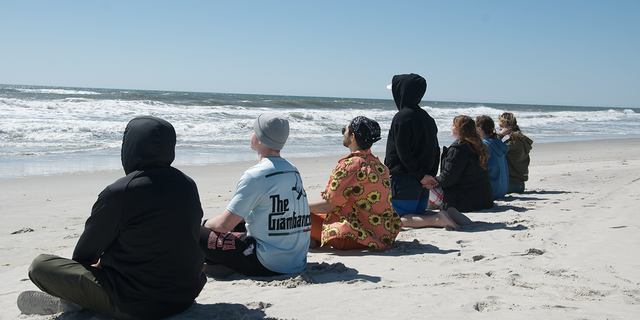 The Wim Hof Method is broken down into three pillars: cold water immersion, breathing and mindset. Long Island polar plunge group Sunday Swim practices breathing on the beach on a cold day in March 2023.