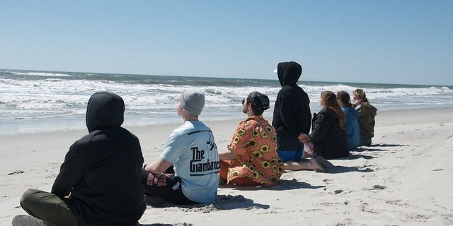 The Wim Hof Method is broken down into three pillars: cold water immersion, breathing and mindset. Long Island polar plunge group Sunday Swim practices breathing on the beach on a cold day in March 2023.