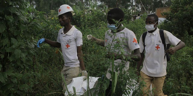 Red Cross volunteers carry the body of a civilian, who was killed in the Democratic Republic of Congo village of Mukondi on March 9, 2023.