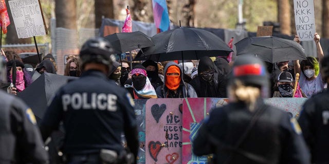 Protesters confront police on March 10 after marching to the California State Capitol to protest a ''Detransition Awareness Day'' event.