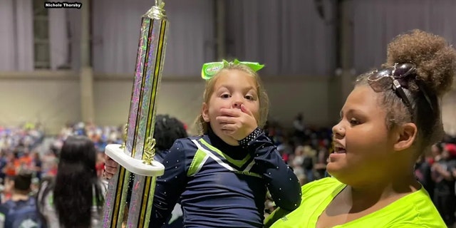 Peyton Thorsby appears to be in shock after winning the first-place trophy for her solo cheer competition performance.