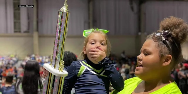 Peyton Thorsby appears to be in shock after winning the first-place trophy for her solo cheer competition performance.