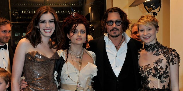 Mia Wasikowska stands with her "Alice in Wonderland" cast mates Anne Hathaway, Helena Bonham Carter and Johnny Depp in 2010. 
