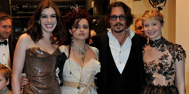 Mia Wasikowska stands with her "Alice in Wonderland" cast mates Anne Hathaway, Helena Bonham Carter and Johnny Depp in 2010. 