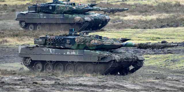 Two Leopard 2 tanks are seen in action in Augustdorf, Germany, on Feb. 1, 2023. Germany wants to buy back mothballed Leopard 2 tanks from Switzerland to replace tanks that the country is sending to Ukraine.