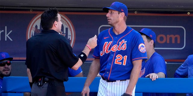 New York Mets starting pitcher Max Scherzer (21) talks with home plate umpire David Rackley after working out during the second inning of a spring training baseball game against the Washington Nationals on Sunday, February 26. 2023 in Port St. Lucie, Florida. 