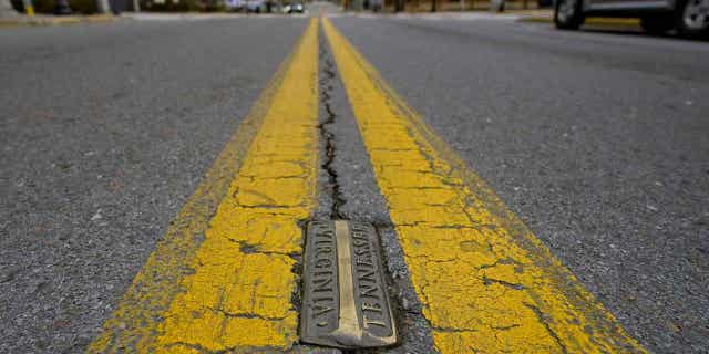 Brass markers mark the state line between Tennessee and Virginia on State Street in Bristol, Virginia, on Feb. 23, 2023. Residents in southwestern Virginia have battled for months over whether abortion clinics limited by strict laws in other states should be allowed to hop over the border and operate there.