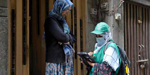 A government employee collects data from a woman during a census in Lahore, Pakistan March 1, 2023. The country has launched its first-ever digital census in a bid to gather regional demographic data ahead of upcoming elections.