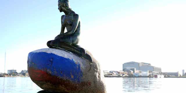 The Russian flag is painted on the stone where the Little Mermaid sits after the statue was vandalized in Copenhagen, Denmark, on March 2, 2023.