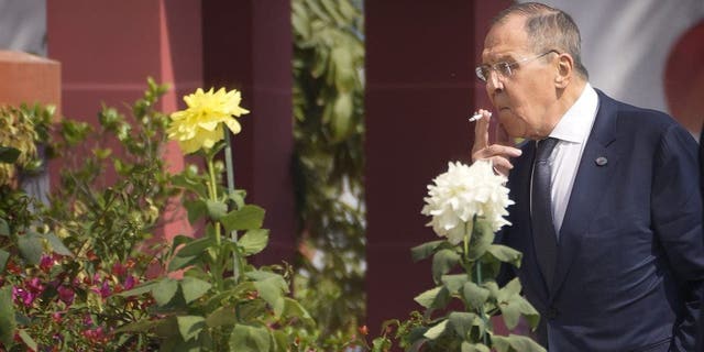 Russian Foreign Minister Sergey Lavrov smokes as he walks to attend the second session of the G20 foreign ministers meeting, in New Delhi, India on Thursday, March 2, 2023. 