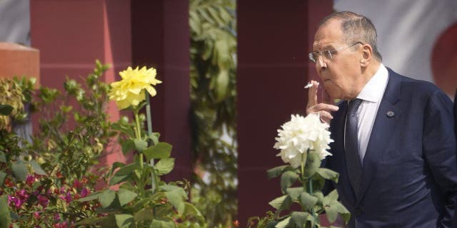 Russian Foreign Minister Sergey Lavrov smokes as he walks to attend the second session of the G20 foreign ministers meeting, in New Delhi, India, Thursday, March 2, 2023.