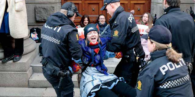 Activists are carried away by the police during a protest against a wind farm that hinders the Sami indigenous peoples' ability to raise reindeer in Oslo, Norway, on March 2, 2023.