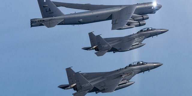 In this photo provided by South Korea Defense Ministry, a U.S. Air Force B-52H Stratofortress aircraft, top, flies in formation with South Korea's Air Force F-15K fighters over the western sea of Korean peninsula during a joint air drill in South Korea, Monday, March 6, 2023.