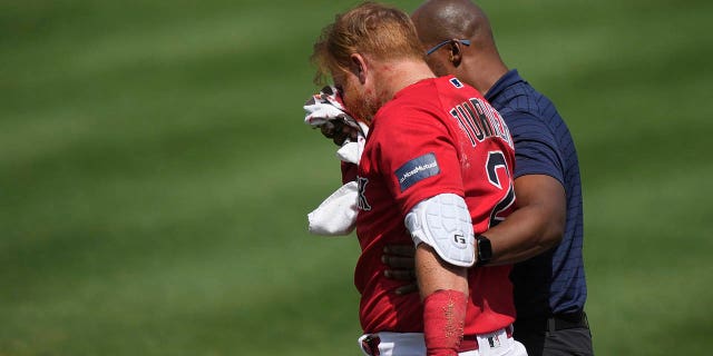 Justin Turner, de los Medias Rojas de Boston, sale del campo después de ser golpeado en la cara con un lanzamiento durante un juego de entrenamiento de primavera en Fort Myers, Florida, el lunes 6 de marzo de 2023.